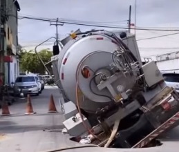 Asfalto cede e caminhão cai em buraco no bairro Panamericano, em Fortaleza