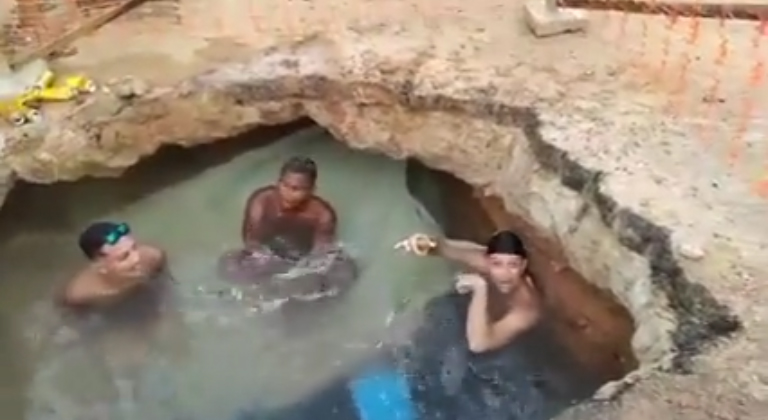 Com isopor e cerveja, homens tomam banho em buraco de obra em rua; veja vídeo