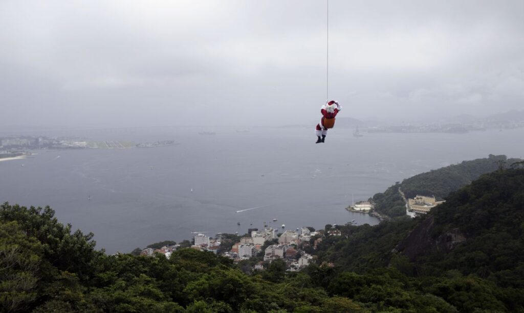 De máscara, Papai Noel chega de rapel ao Rio de Janeiro