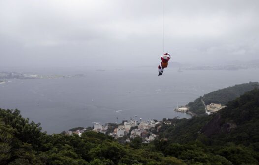 De máscara, Papai Noel chega de rapel ao Rio de Janeiro