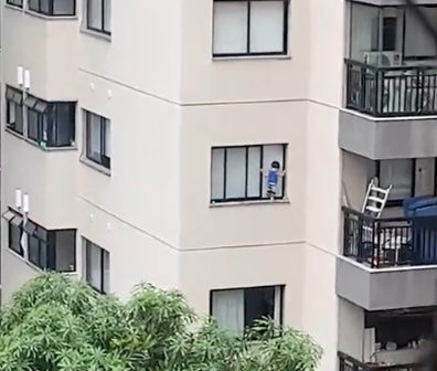 Vídeo mostra menino pendurado na janela de apartamento