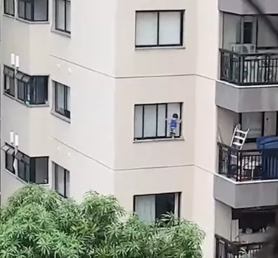 Vídeo mostra menino pendurado na janela de apartamento