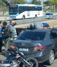 Homem para em cima de teto de carro após acidente