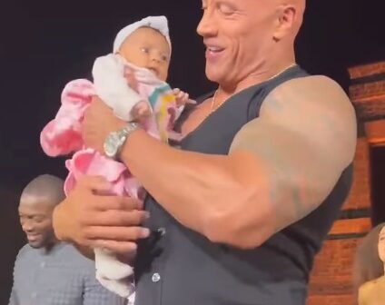 Pai passa bebê por multidão até chegar em Dwayne Johnson, The Rock, durante evento