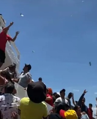 Homem joga dinheiro para romeiros em Juazeiro do Norte