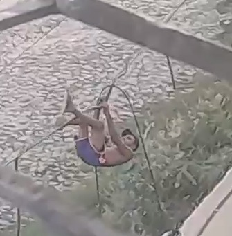 Homem é flagrado se pendurando em fiação para roubar fios