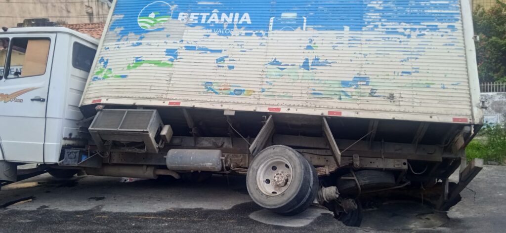 Caminhão cai em buraco após asfalto ceder no Bairro Jardim América, em Fortaleza