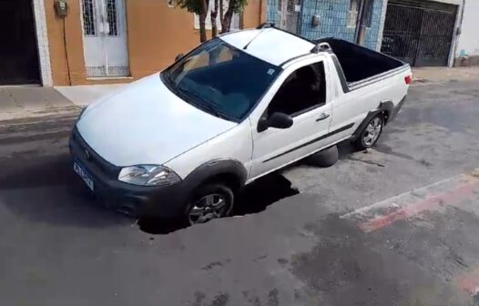 Carro cai em cratera no asfalto no bairro Joaquim Távora, em Fortaleza