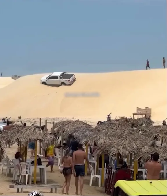 Motorista tenta atravessar duna em praia do Ceará e caminhonete fica inclinada