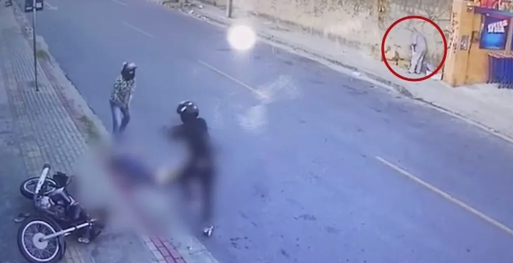 Homens de capacete executam homem à queima-roupa na frente de criança