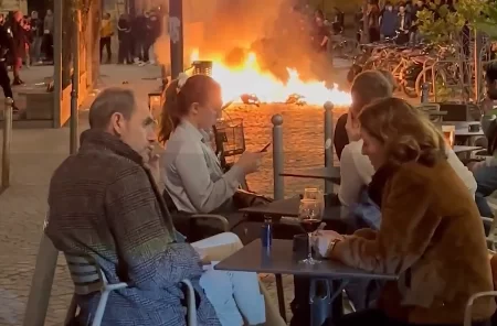 Franceses tomam vinho enquanto manifestantes fazem fogueira em protesto